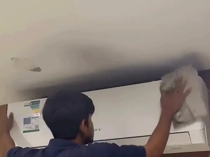 فني أعماق الرمال أثناء غسيل مكيف سبليت في الأحساء